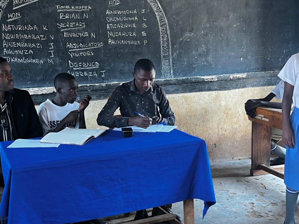 Adjudicators and the debate roster during a School Mentorship Programme session