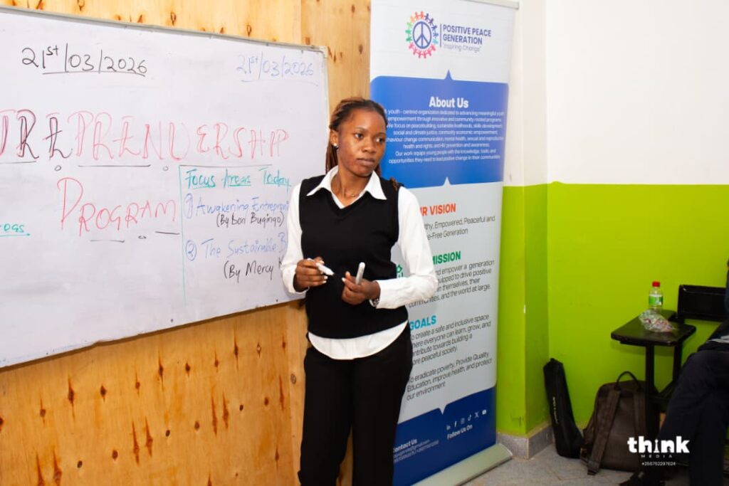 A facilitator opening an Entrepreneurship 4 Peace session at the whiteboard beside the PPG banner