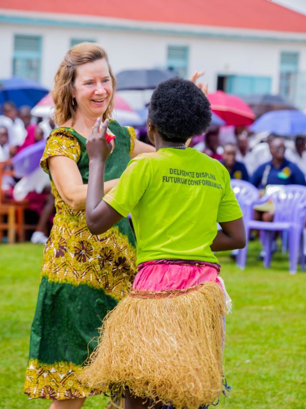 An international guest dancing with a student performer in traditional dress at the Peace Festival