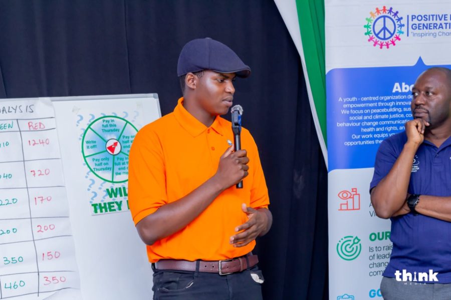 An Entrepreneurship 4 Peace participant pitching to the room with a Rotary mentor listening