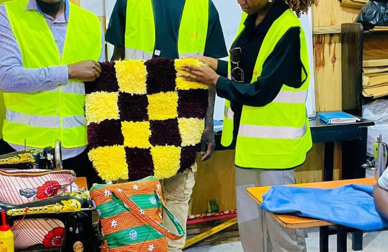 She Means Business trainees presenting a finished handmade rug in the tailoring and sustainable fashion workshop
