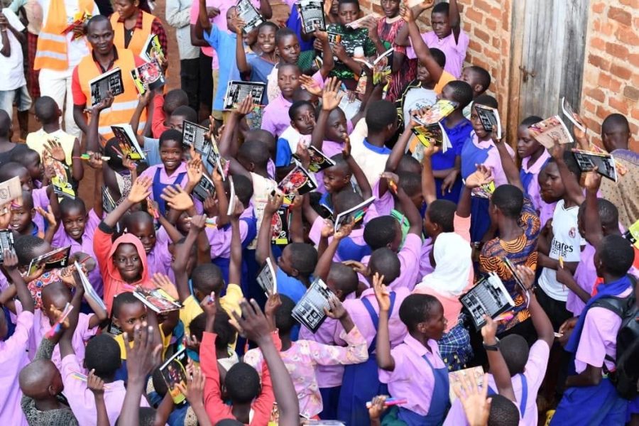 Pupils raising scholastic materials distributed through the Iziragobi Project